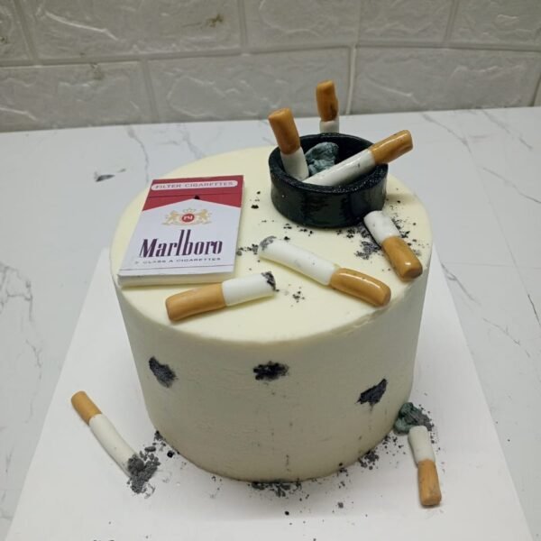 White cylindrical birthday cake featuring edible Marlboro cigarette pack, black ashtray, and cigarette butt decorations for "Fari" birthday.